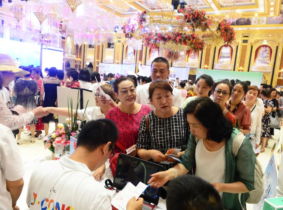 领奖区,人头攒动,大家纷纷排队领取礼品,脸上洋溢着开心的笑容.